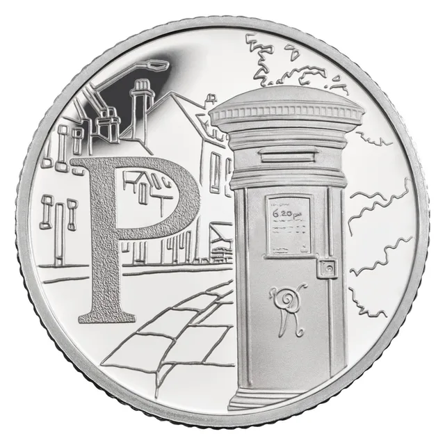 A pillar box on a street with houses, chimneys and a street lamp behind, beside a large letter P