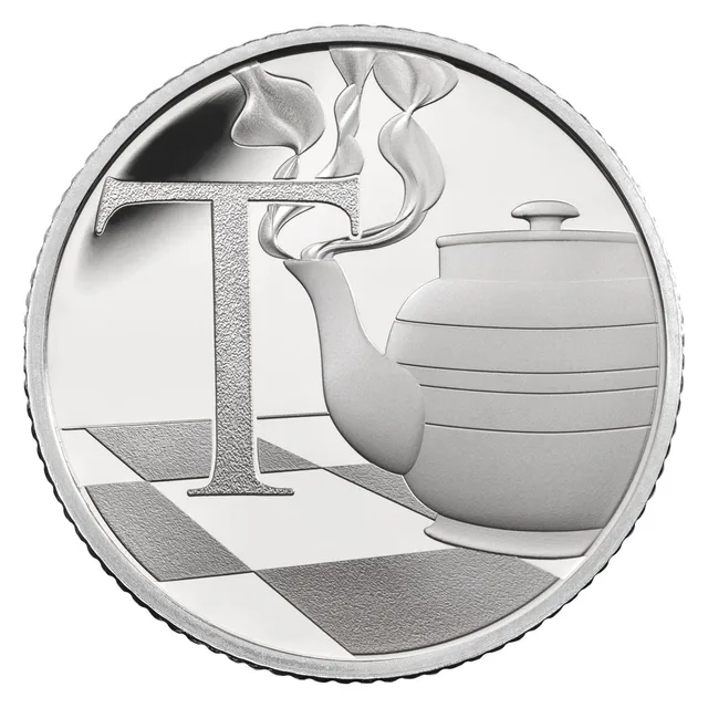 A steaming traditional teapot on a chequered surface to the right of a large capital letter T
