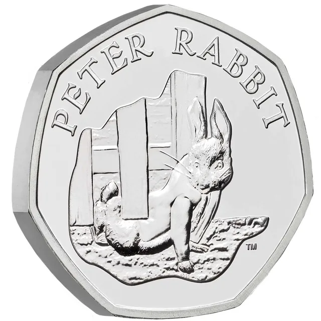 Peter Rabbit in his jacket scrambling under Mr McGregor's fence, with the name PETER RABBIT and a small TM mark